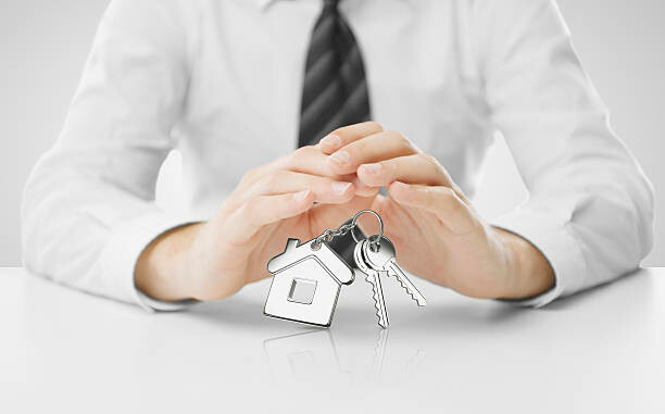 businessman hands covering keys with key chain
